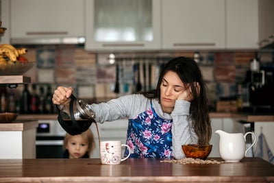 woman pouring coffee while showing symptoms of sleep deprivation