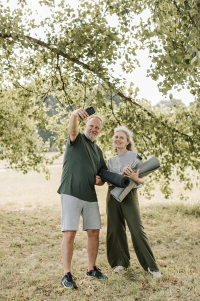 Man and woman taking a selfie just after having completed yoga. 