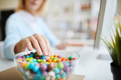 woman reaching for candy wondering is sugar good for you 