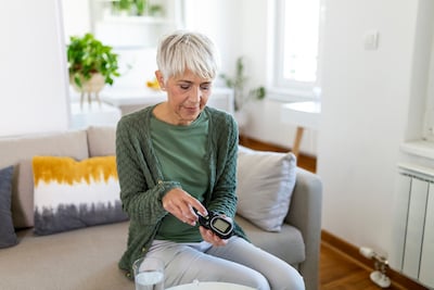 woman checking her blood sugar for diabetes which has a connection with heart disease 