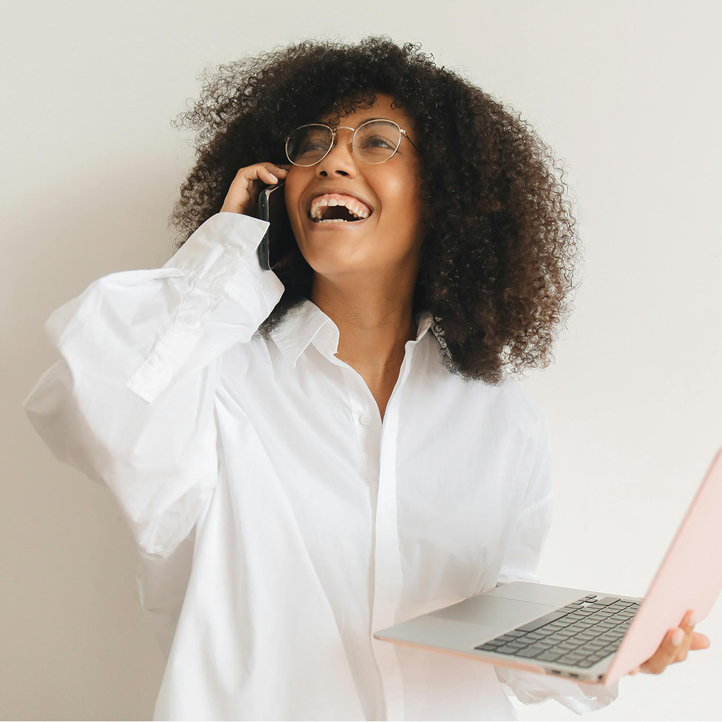 Black woman smiling and talking on her cell phone